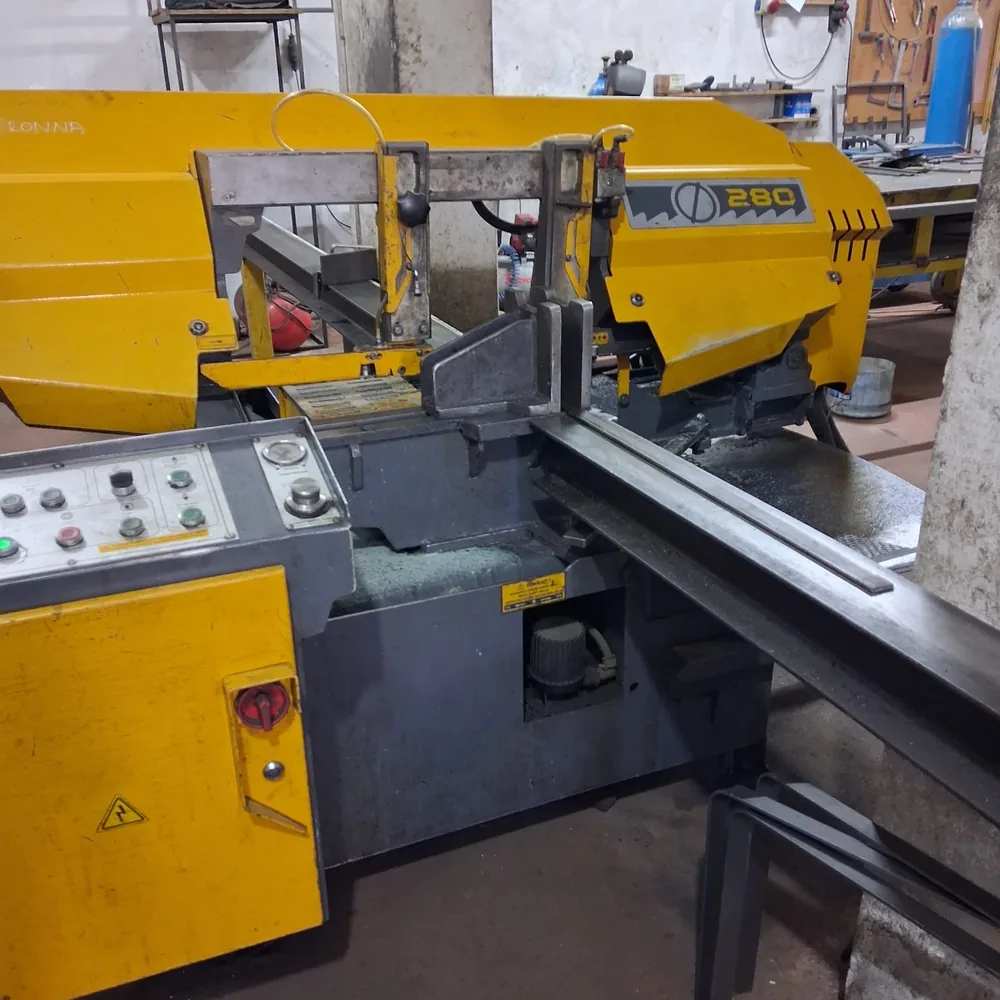 Bandsaw cutting a length of steel section for a ceiling mirror frame