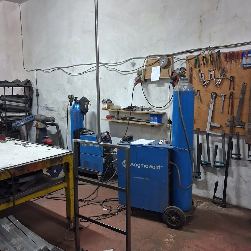 The welding bay &mdash; MIG set, gas bottles and a board of hand tools, with a steel frame standing ready